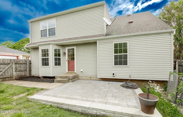 rear view of house with fence, a patio, and roof with shingles
