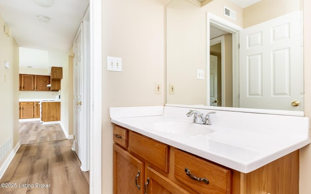bathroom featuring wood finished floors, vanity, and baseboards