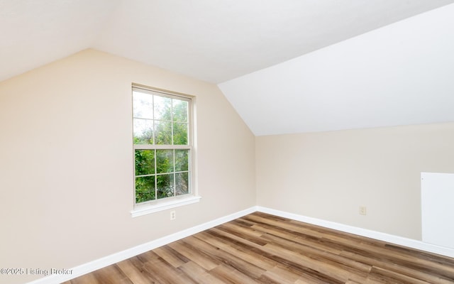 bonus room with lofted ceiling, wood finished floors, and baseboards