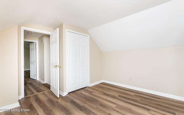 additional living space with wood finished floors, baseboards, and vaulted ceiling