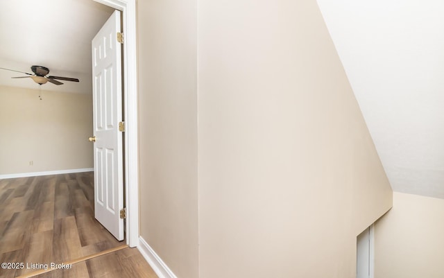 corridor with wood finished floors and baseboards