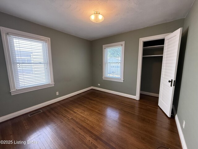 612 Ervay Ave, Louisville, KY 40217 - unfurnished bedroom with baseboards, dark wood finished floors, and a closet
