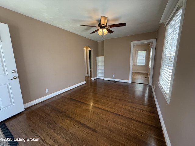612 Ervay Ave, Louisville, KY 40217 - unfurnished room with baseboards, a ceiling fan, arched walkways, and dark wood-type flooring