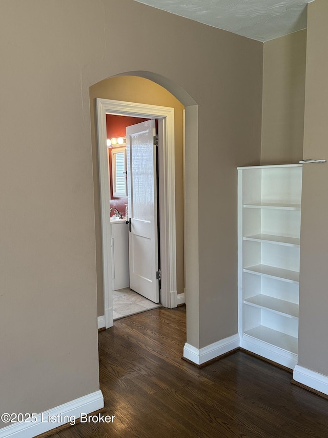 612 Ervay Ave, Louisville, KY 40217 - hallway featuring arched walkways, baseboards, and wood finished floors