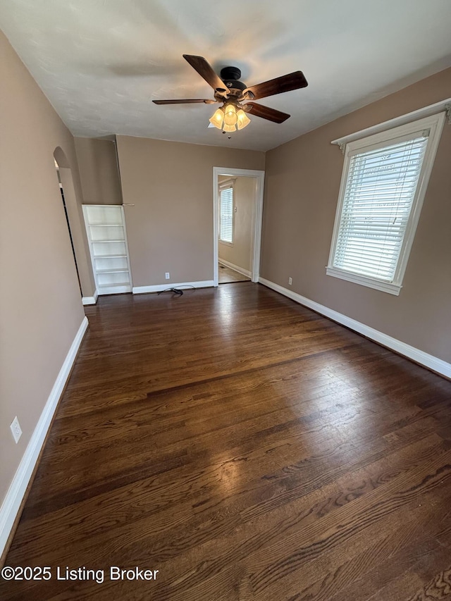 612 Ervay Ave, Louisville, KY 40217 - empty room with baseboards, arched walkways, a ceiling fan, and dark wood finished floors