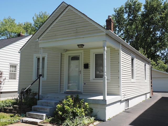 612 Ervay Ave, Louisville, KY 40217 - view of front of property featuring a chimney, a porch, an outbuilding, and a garage