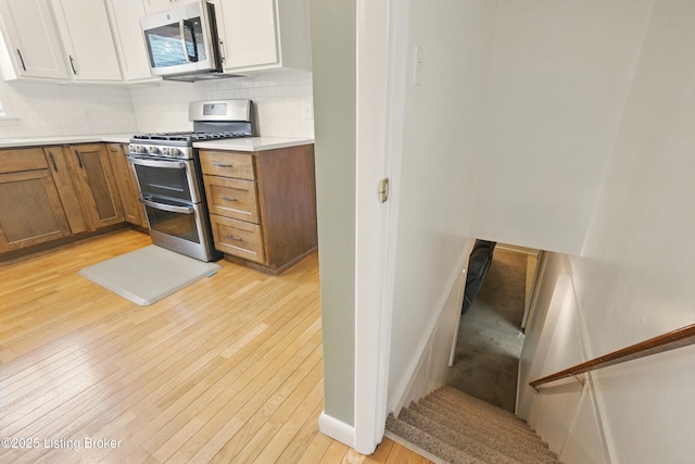 3745 Rosemont Blvd, Louisville, KY 40218 - kitchen with appliances with stainless steel finishes, light wood-style flooring, decorative backsplash, light countertops, and baseboards