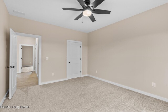 unfurnished bedroom with light colored carpet, baseboards, and ceiling fan
