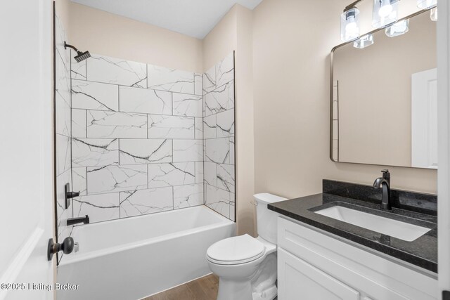 bathroom featuring wood finished floors, toilet, vanity, and shower / washtub combination