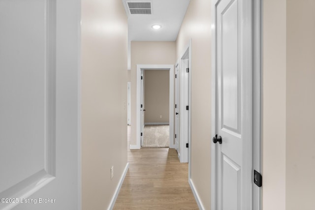 corridor featuring light wood-style floors, baseboards, and recessed lighting