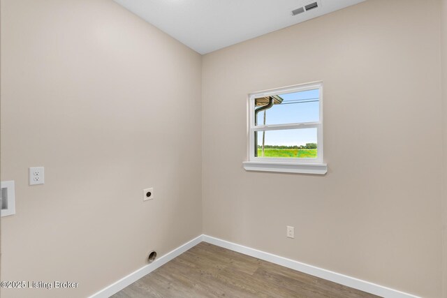 washroom with hookup for an electric dryer, baseboards, and wood finished floors