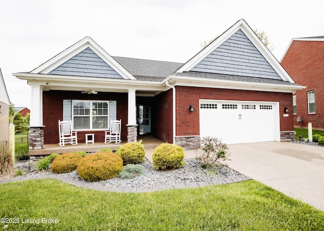 8812 Sanctuary Ln, Louisville, KY 40291 - view of front of home featuring covered porch, an attached garage, concrete driveway, stone siding, and roof with shingles