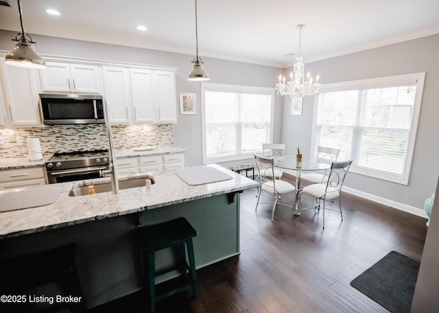 8812 Sanctuary Ln, Louisville, KY 40291 - kitchen featuring appliances with stainless steel finishes, decorative backsplash, white cabinets, light stone counters, and a chandelier