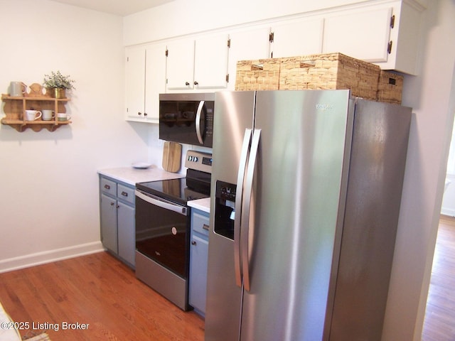132 Goodloe Ave, Bloomfield, KY 40008 - kitchen with stainless steel appliances, white cabinets, wood finished floors, baseboards, and light countertops