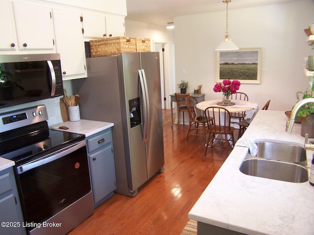132 Goodloe Ave, Bloomfield, KY 40008 - kitchen with stainless steel appliances, a sink, light wood-style flooring, and light countertops
