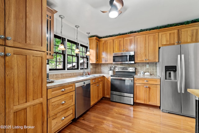 2512 Hounz Ln, Louisville, KY 40223 - kitchen featuring stainless steel appliances, a sink, light wood-type flooring, tasteful backsplash, and tile counters