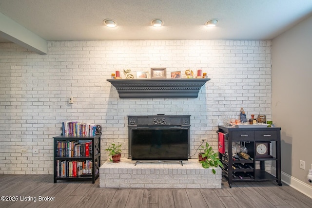 395 Poplar Trce, Elizabethtown, KY 42701 - living area featuring brick wall, wood finished floors, a fireplace, and baseboards
