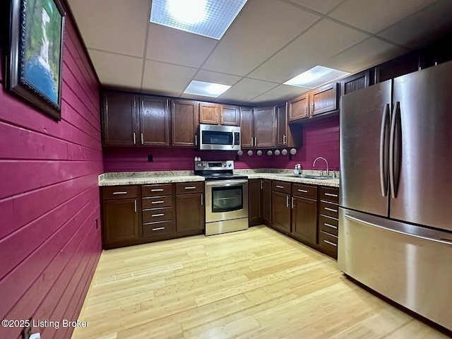 2212 Duff Rd, Leitchfield, KY 42754 - kitchen with stainless steel appliances, a drop ceiling, light wood-type flooring, a sink, and wood walls