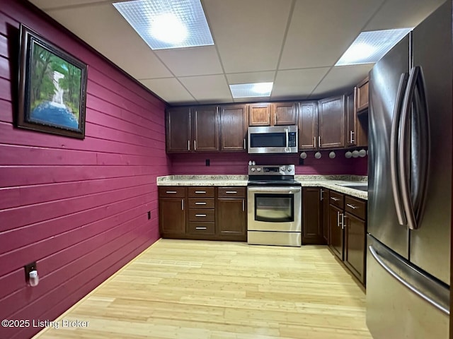 2212 Duff Rd, Leitchfield, KY 42754 - kitchen with appliances with stainless steel finishes, light countertops, light wood-style floors, a drop ceiling, and dark brown cabinets