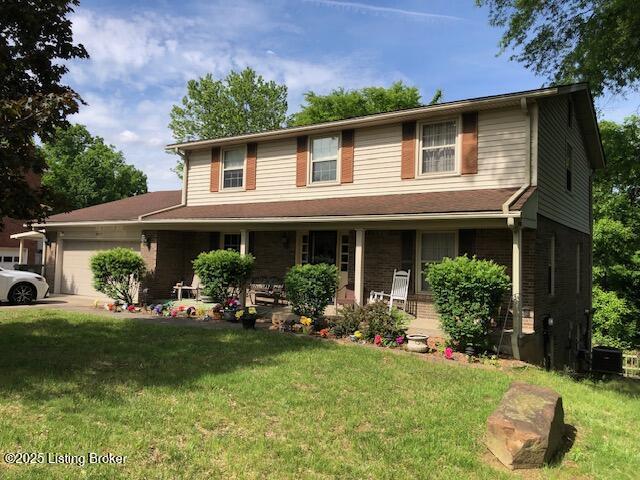 8907 Lakeridge Dr, Louisville, KY 40272 - view of front of home with covered porch, a garage, and a front yard