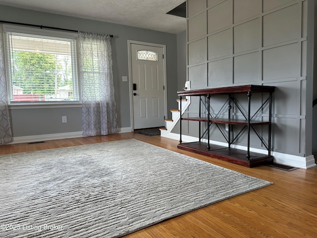 4908 Fielding Way, Louisville, KY 40216 - foyer with baseboards, wood finished floors, a textured ceiling, and stairs