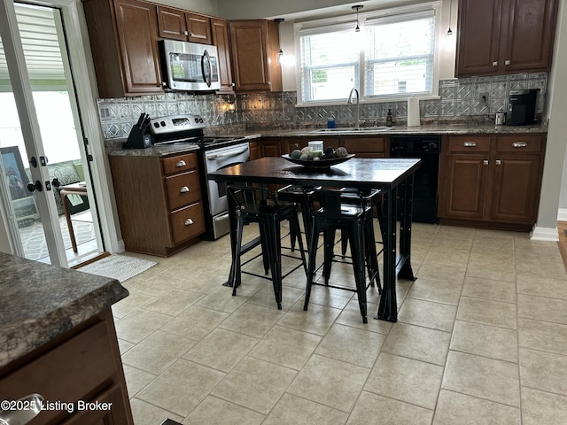 4908 Fielding Way, Louisville, KY 40216 - kitchen with appliances with stainless steel finishes, a sink, dark countertops, and decorative backsplash