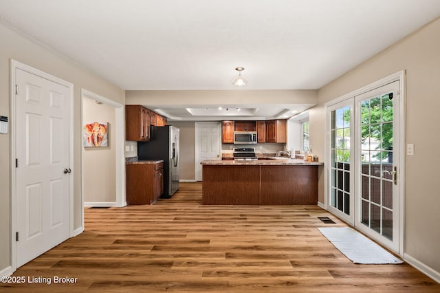 10707 Hickory Cove Ct, Louisville, KY 40245 - kitchen with appliances with stainless steel finishes, light wood-type flooring, a peninsula, and baseboards