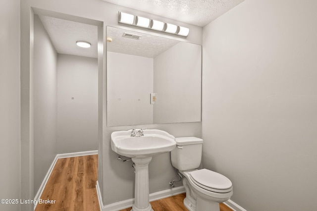 10707 Hickory Cove Ct, Louisville, KY 40245 - bathroom with a textured ceiling, toilet, wood finished floors, and baseboards
