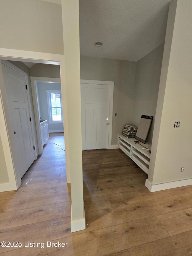 hall with light wood-type flooring and baseboards