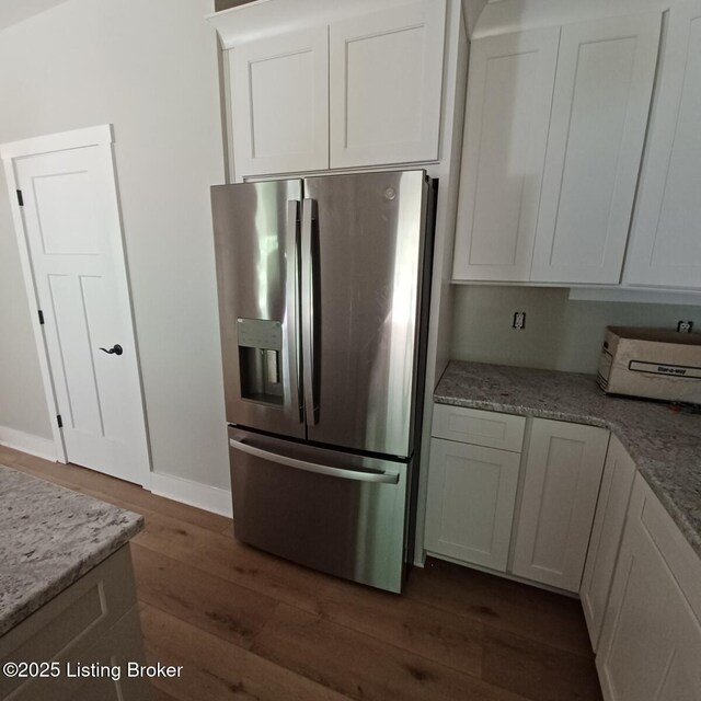 7001 Stable Ct, Crestwood, KY 40014 - kitchen featuring stainless steel refrigerator with ice dispenser, dark wood-style flooring, white cabinets, light stone counters, and baseboards