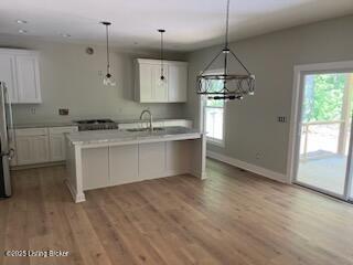7001 Stable Ct, Crestwood, KY 40014 - kitchen featuring light countertops, white cabinetry, a chandelier, light wood finished floors, and baseboards