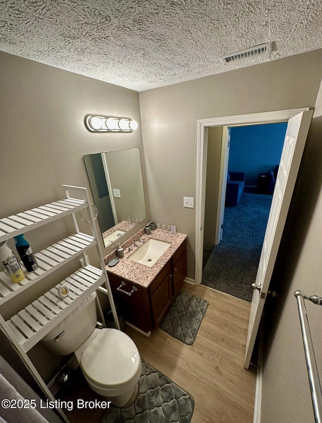 2512 S 4th St, Louisville, KY 40208 - bathroom featuring wood finished floors, vanity, a textured ceiling, and toilet