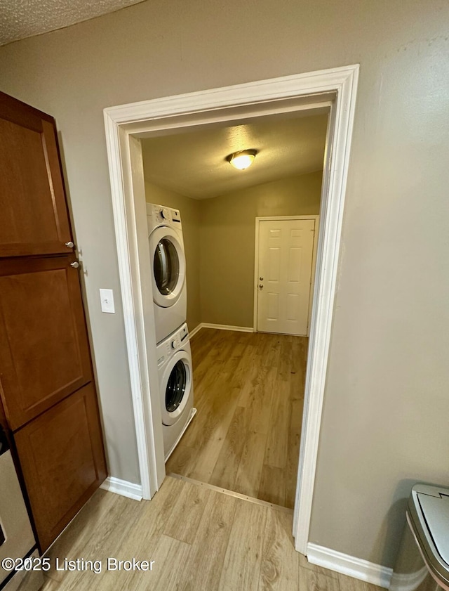 2512 S 4th St, Louisville, KY 40208 - washroom featuring estacked washer and dryer, light wood-style floors, and baseboards