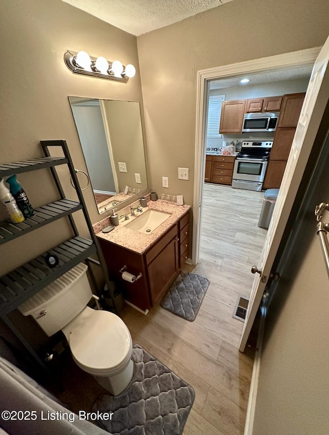 2512 S 4th St, Louisville, KY 40208 - bathroom with wood finished floors, vanity, and a textured ceiling