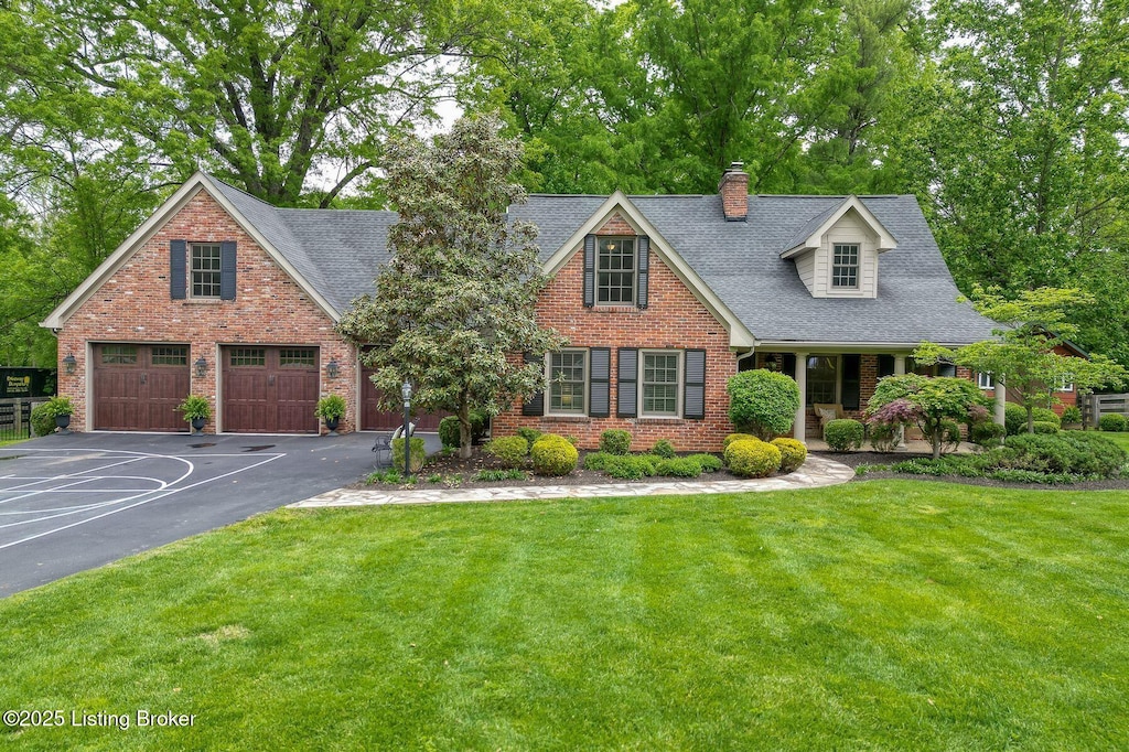 12209 Locust Ln, Anchorage, KY 40223 - view of front of house with brick siding, a front yard, driveway, and a shingled roof