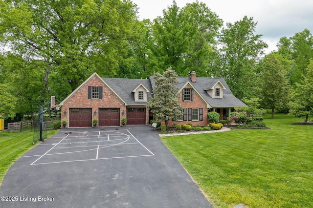 view of front of property with a garage, brick siding, a chimney, and view of wooded area
