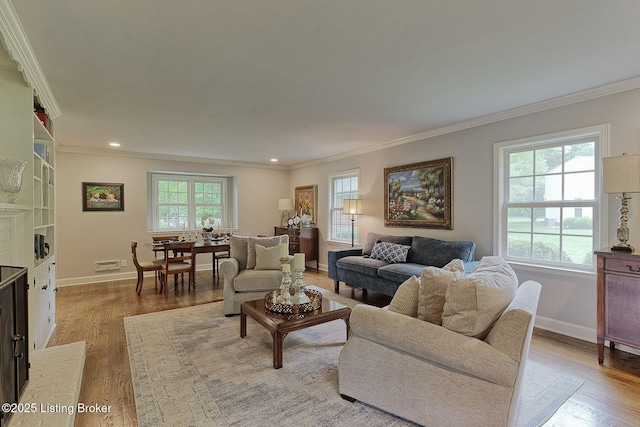 living area featuring ornamental molding, light wood-style floors, baseboards, and recessed lighting