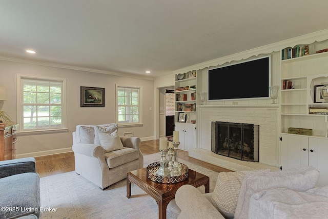 living room featuring crown molding, wood finished floors, baseboards, a fireplace, and recessed lighting