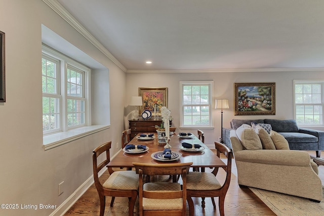 dining room featuring plenty of natural light, wood finished floors, crown molding, baseboards, and recessed lighting