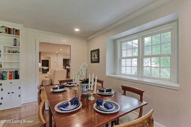 dining area with ornamental molding, wood finished floors, and baseboards