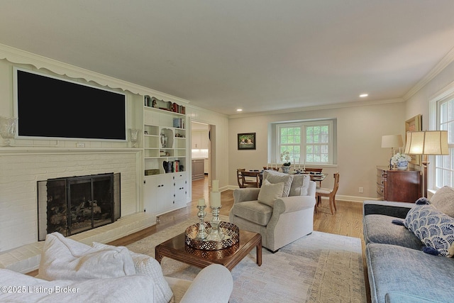 living area with healthy amount of natural light, crown molding, light wood finished floors, baseboards, and recessed lighting