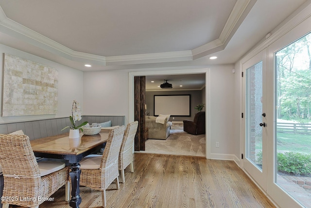 dining space featuring crown molding, wood finished floors, a tray ceiling, and recessed lighting