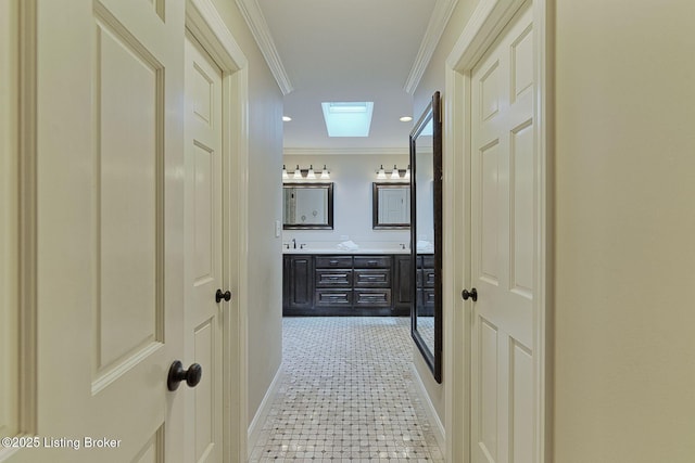 hall with baseboards, a skylight, and crown molding