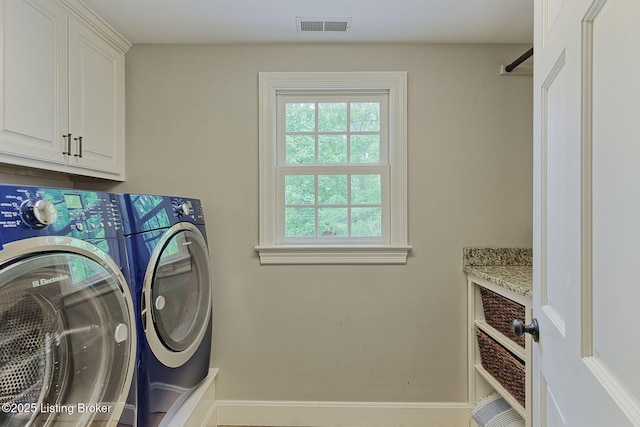 laundry area featuring cabinet space, separate washer and dryer, and baseboards