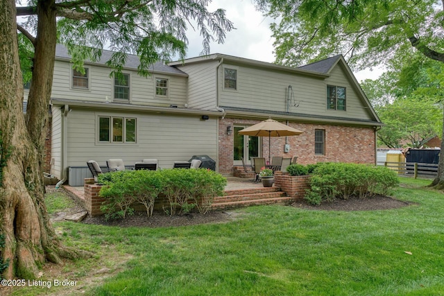 rear view of house with a patio and brick siding