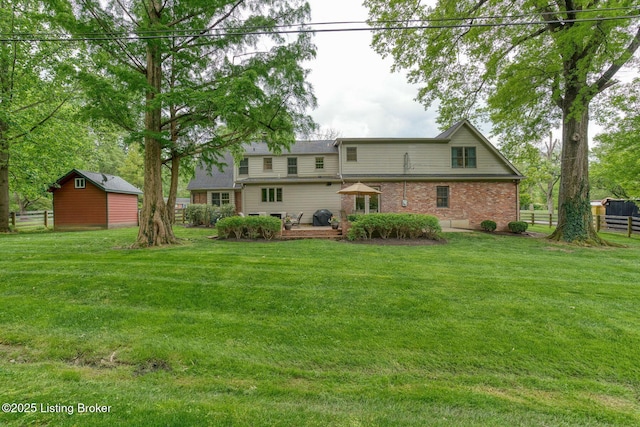 rear view of house with brick siding, a wooden deck, and an outbuilding