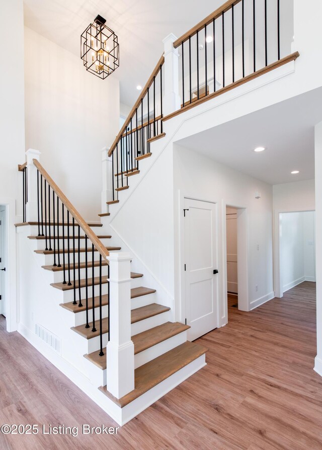 4227 Stilger Cir, Louisville, KY 40299 - stairway with wood finished floors, baseboards, recessed lighting, and a towering ceiling