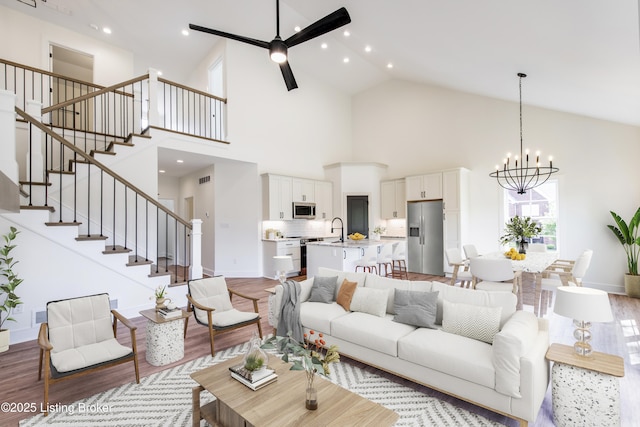 4227 Stilger Cir, Louisville, KY 40299 - living room featuring a chandelier, light wood finished floors, stairway, high vaulted ceiling, and recessed lighting