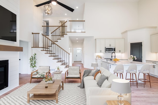 4227 Stilger Cir, Louisville, KY 40299 - living area with a towering ceiling, stairway, light wood finished floors, and a large fireplace
