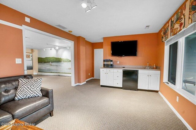living area with light carpet, rail lighting, and baseboards